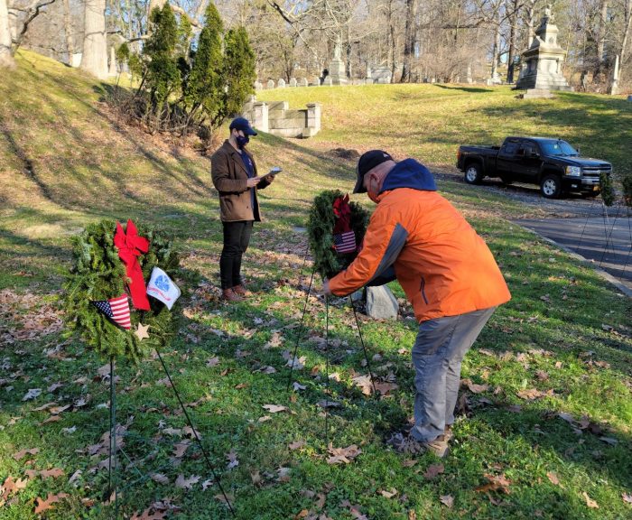 Veteran laying wreath in cemetery.